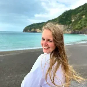 žena v bílé mikině na pláži na Azorech