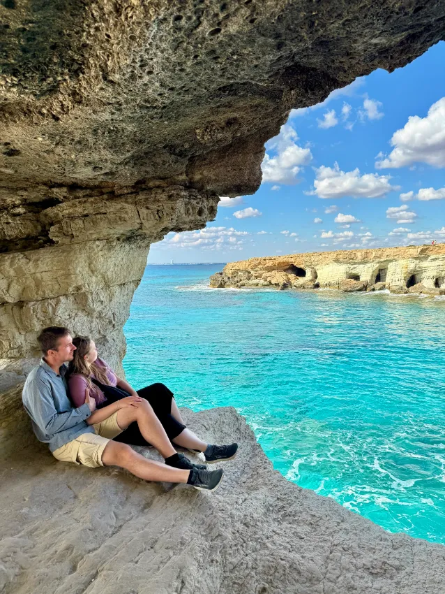 pár v objetí ve skalním oblouku na Sea Caves na Kypru